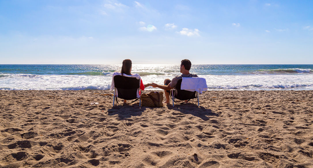 couple sitting in beach chairs on sandy beach