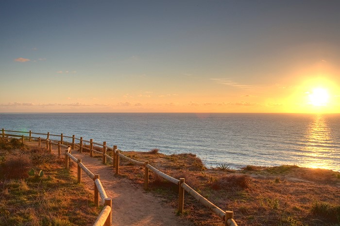 view of hiking trail with ocean and sunset