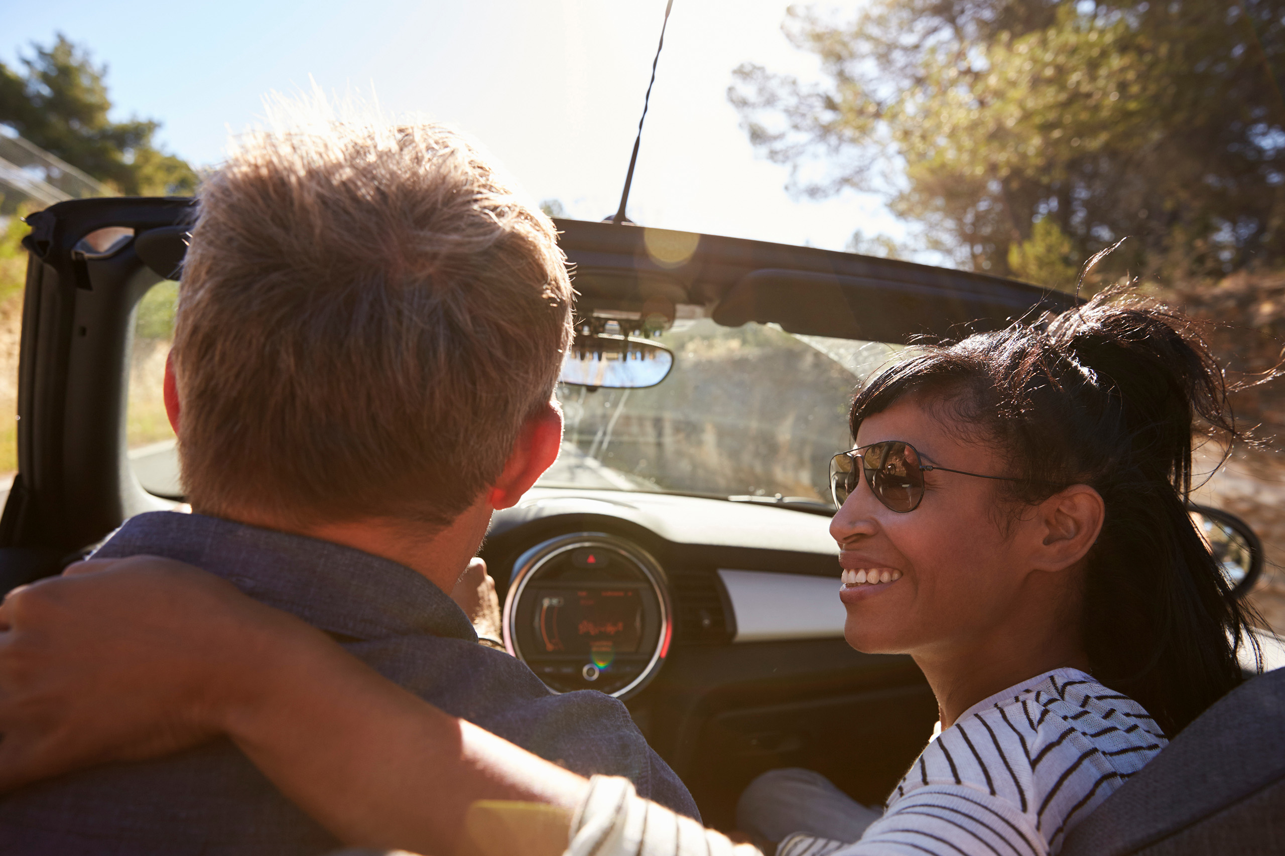 mixed couple in convertible rental car